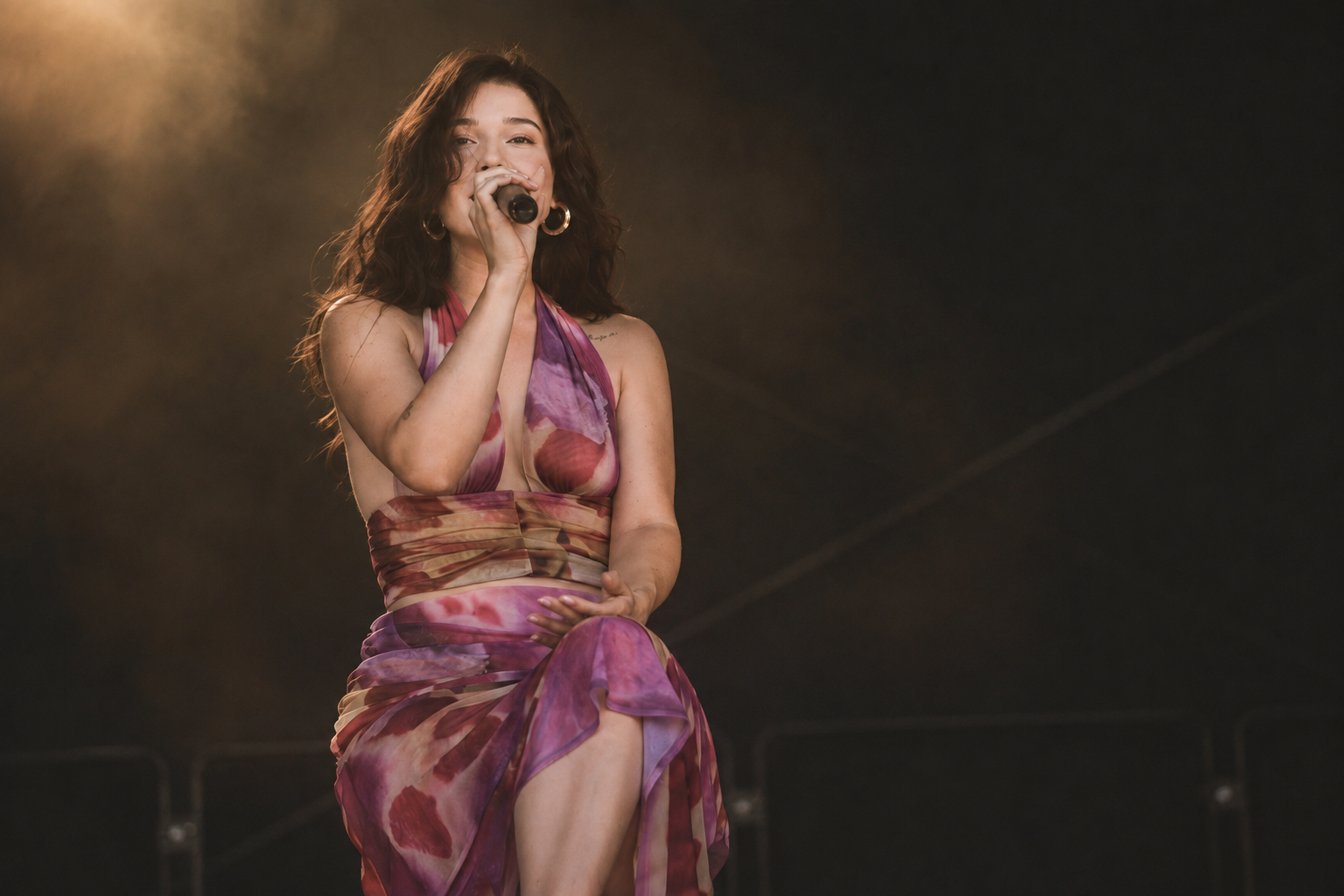 Naomi Astera performing on stage in a flowing pink dress
